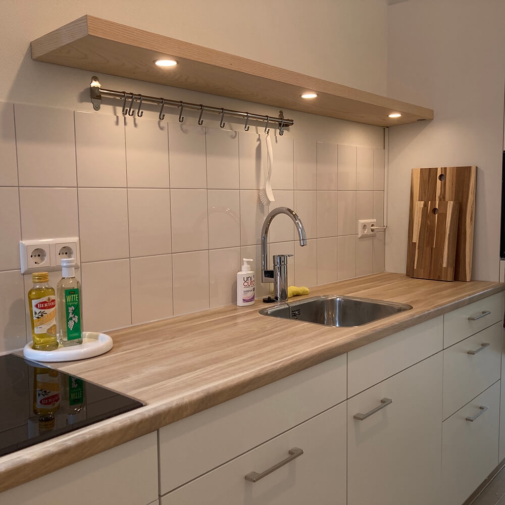 Foto van eiken wandplank met LED spots in keuken - wandplank.nl